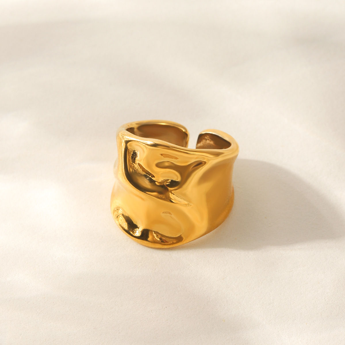 Anel Treviso em aco banhado a ouro com formas fluidas.