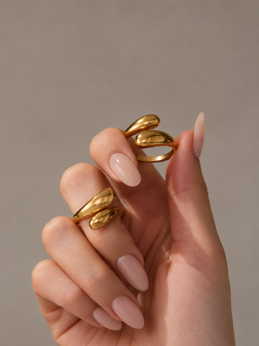 Anel Elora em aco banhado a ouro com formas entrelacadas.